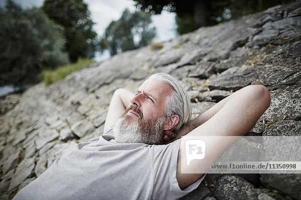 Relaxed bearded mature man at the riverside