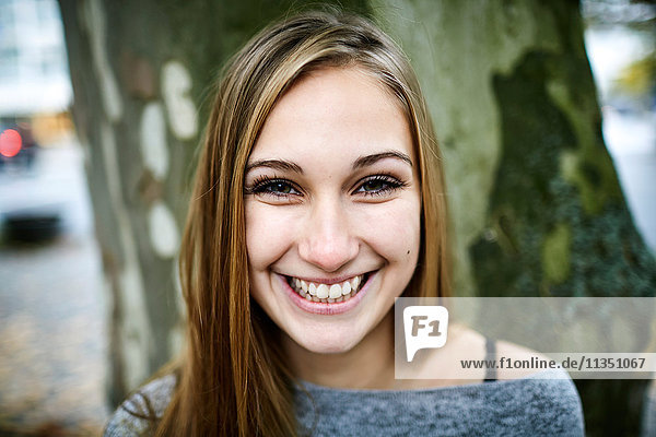 Portrait einer lächelnden jungen Frau im Freien