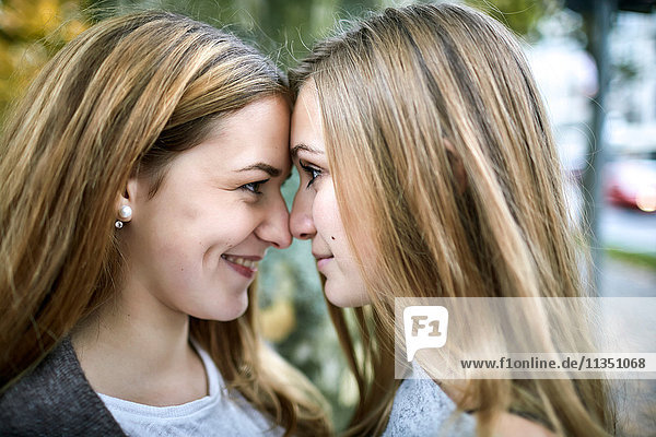 Zwei lächelnde junge Frauen Kopf an Kopf