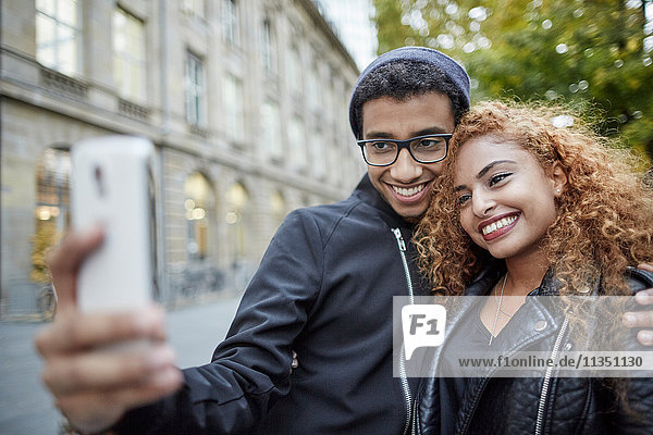 Smiling young couple taking a selfie outdoors