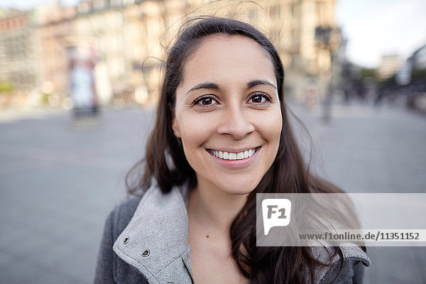 Portrait einer lächelnden Frau in der Stadt