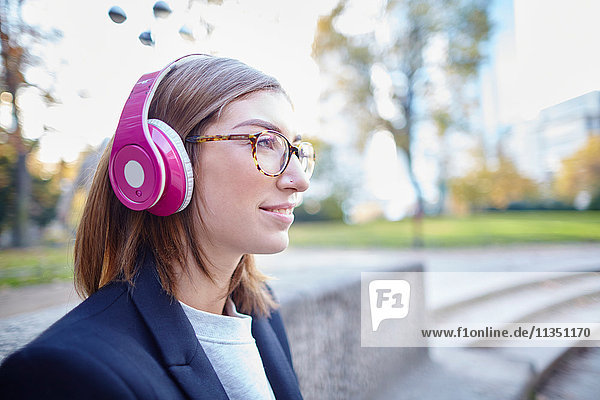 Frau mit Kopfhörern im Freien