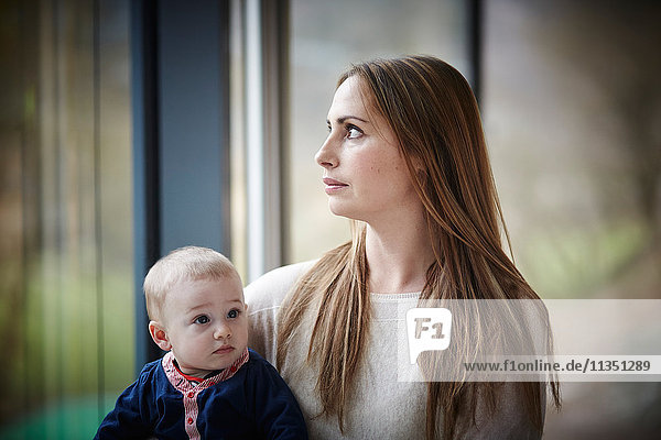 Mutter mit Baby am Fenster