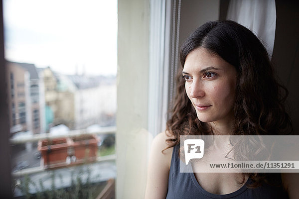 Frau schaut aus dem Fenster