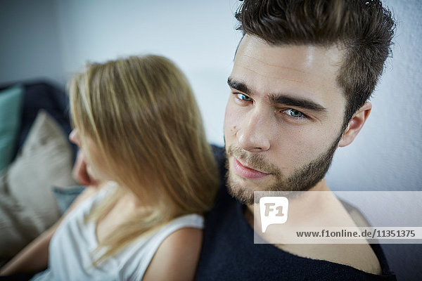 Portrait eines jungen Mannes mit Freundin auf der Couch