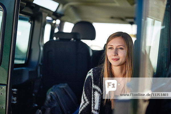 Junge Frau in einem Auto in eine Decke gewickelt