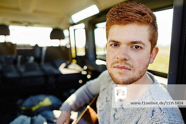 Portrait eines rothaarigen jungen Mannes in einem Auto