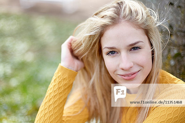 Portrait einer lächelnden jungen Frau im Freien