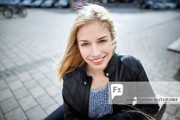 Portrait einer lächelnden jungen Frau im Freien