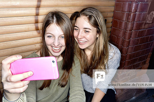 Zwei fröhliche junge Frauen machen ein Selfie