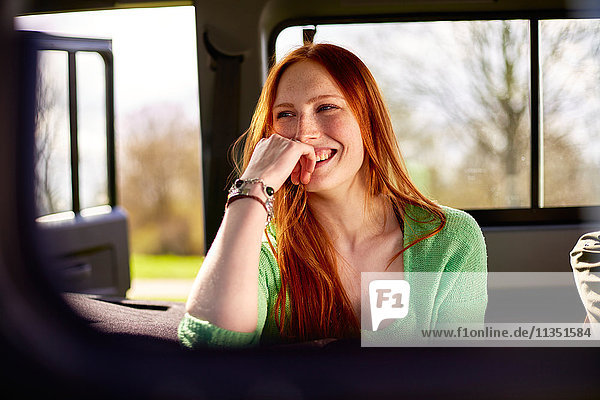 Happy young woman in car
