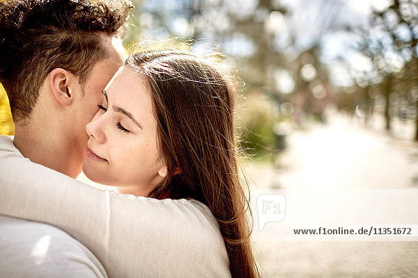 Teenage couple in love hugging outdoors