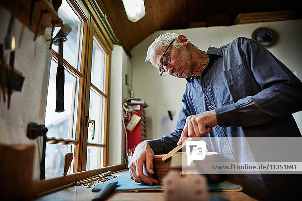 Gitarrenbauer arbeitet in seiner Werkstatt