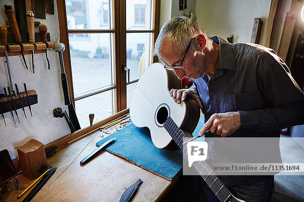 Gitarrenbauer arbeitet in seiner Werkstatt