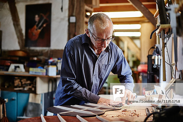 Guitar maker in his workshop at work