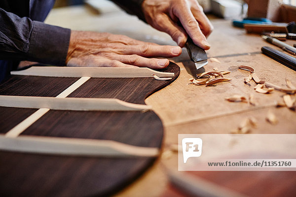 Close-up of a guitar maker at work