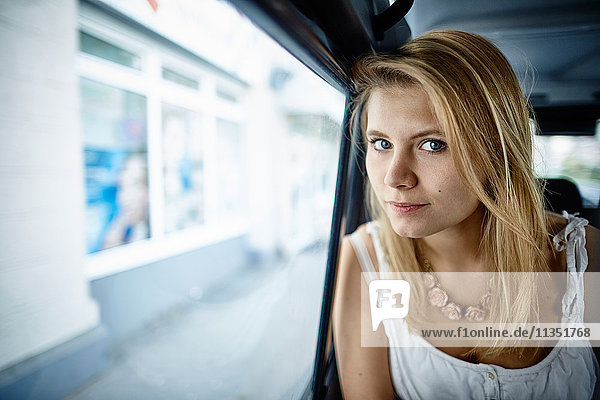 Portrait of young woman inside car