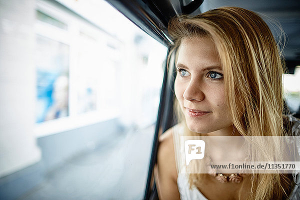 Young woman inside car looking out