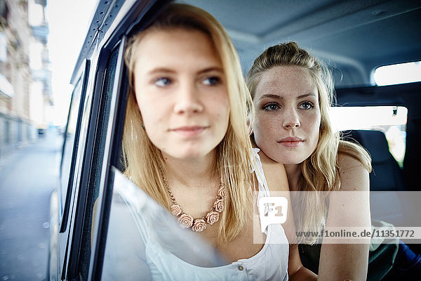 Two young women in car looking out of window