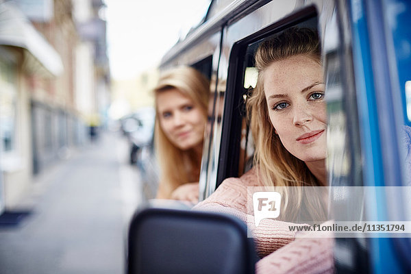 Two young women in car looking out of window