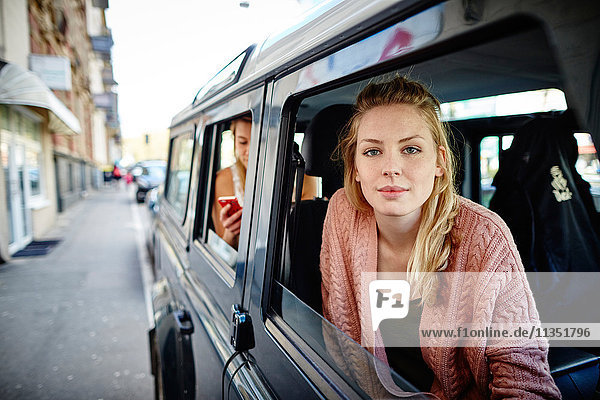 Young woman in car looking out of window