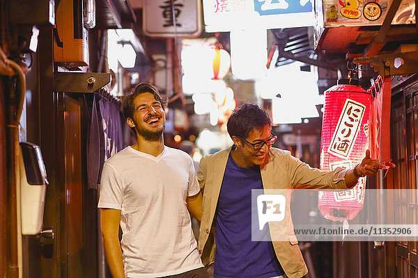 Caucasian man enjoying nightlife in Tokyo with Japanese friend  Japan