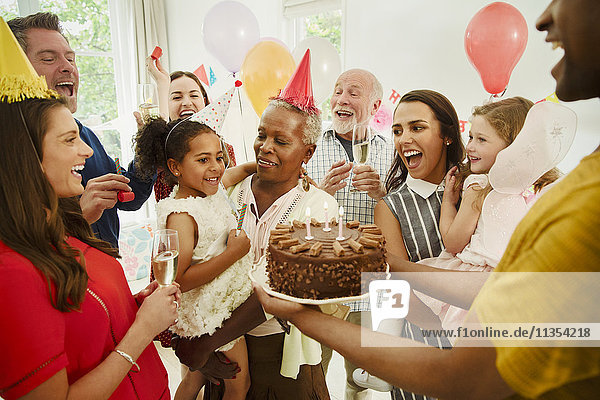 Mehrgenerationen-Familie feiert Geburtstag mit Schokoladenkuchen