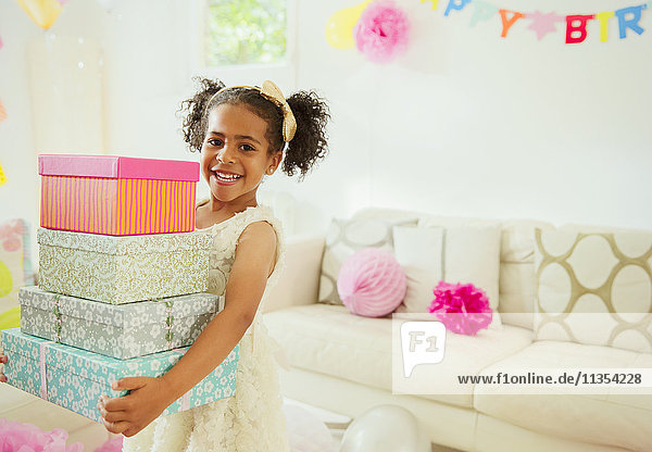 Portrait lächelndes Mädchen mit einem Stapel Geburtstagsgeschenke