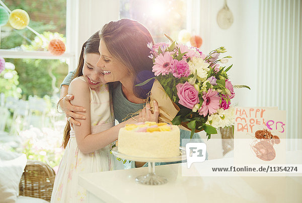 Affectionate daughter giving flower bouquet to mother on Mother’s Day