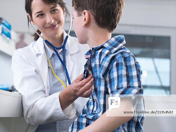 Arzt überprüft die Atmung des Jungen mit dem Stethoskop