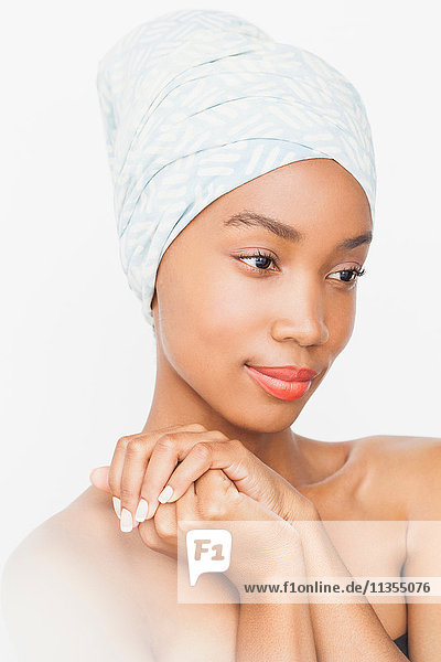 Woman wearing headwrap hands together looking away