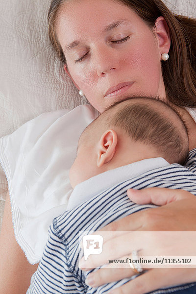 Säugling schläft auf der Brust der Mutter