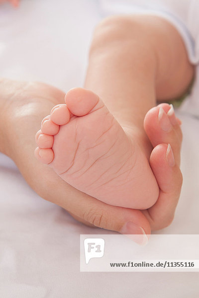 Mütter Hand halten Baby Jungen Fuß
