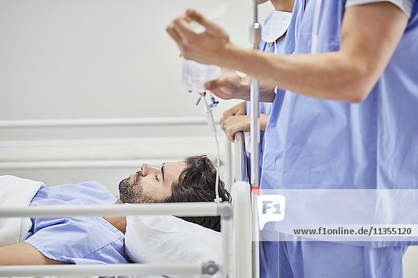 Arzt  der den Patienten im Krankenhausbett medizinisch behandelt