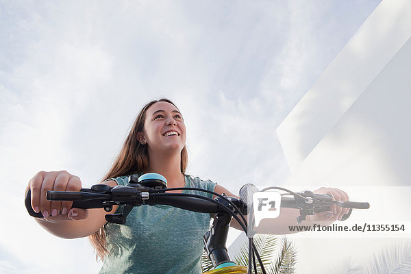 Low angle view of teenage girl cycling on bicycle