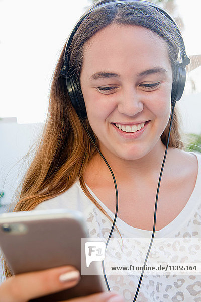 Teenage girl wearing headphones smiling