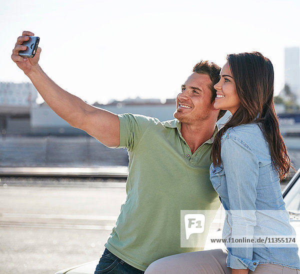 Couple by river taking selfie smiling