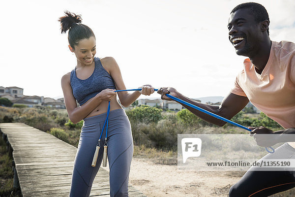Couple tugging on skipping rope smiling