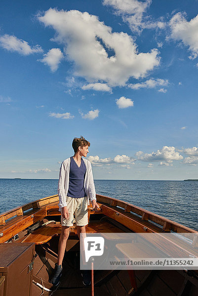 Teenager Junge steht auf Boot und schaut weg