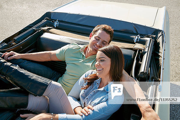 Couple relaxing in convertible car  Los Angeles  California  USA