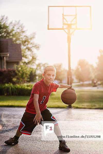 Porträt eines Jungen  der mit Basketball dribbelt
