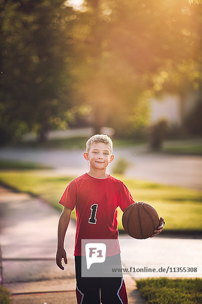 Portrait of young boy holding basketball