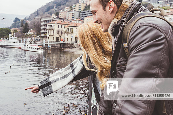 Glückliches junges Paar zeigt auf den See  Comer See  Italien
