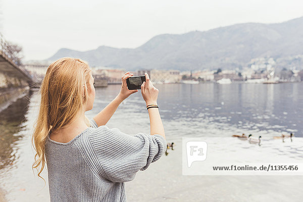 Junge Frau fotografiert vom Comer Seeufer aus  Italien
