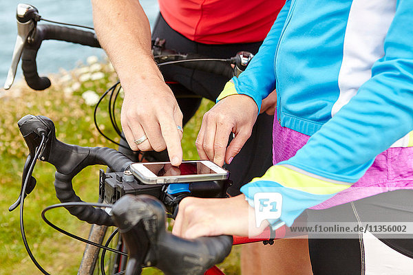 Cyclists stopping to use GPS on mobile phone