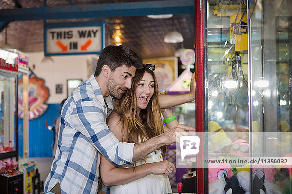 Paar im Vergnügungspark mit einem Arcade-Grabber  Coney Island  Brooklyn  New York  USA