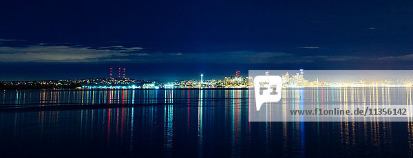 Panoramic view of distant skyline and city lights at night  Seattle  Washington  USA