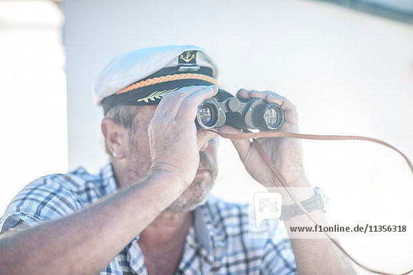 Bootskapitän schaut durch ein Fernglas auf dem Boot  Kapstadt  Südafrika