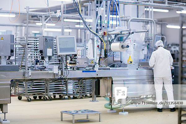 Factory worker operating food production machinery