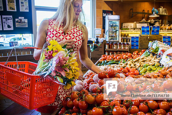 Frau kauft Gemüse im Supermarkt ein